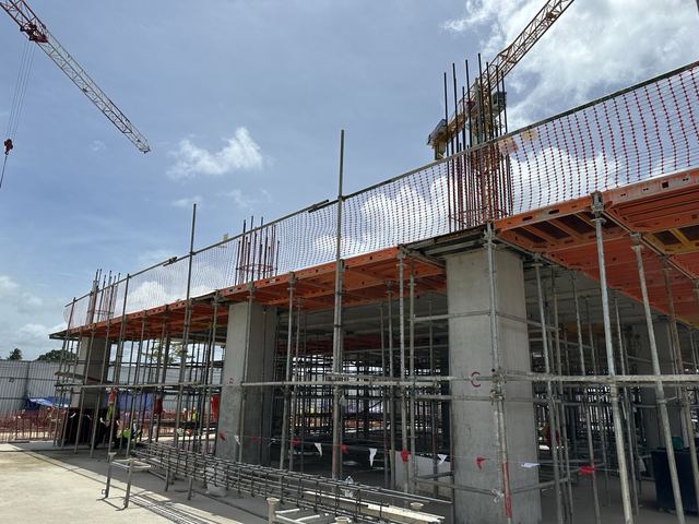 Finished concrete columns supporting orange slab formwork tables